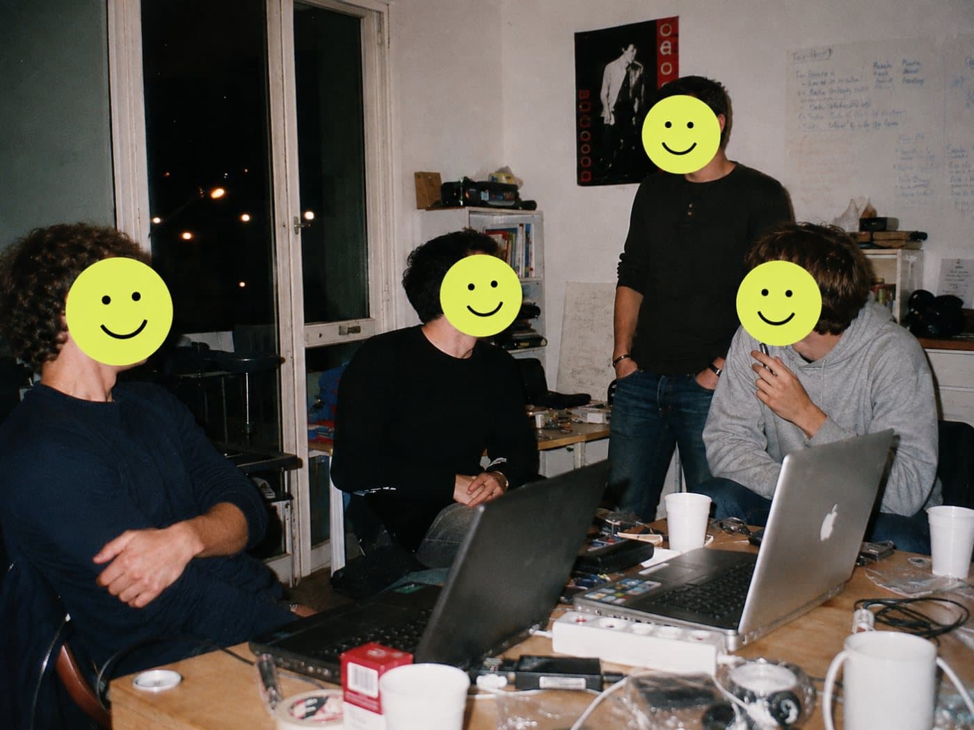 Four founders working late around laptops in their apartment