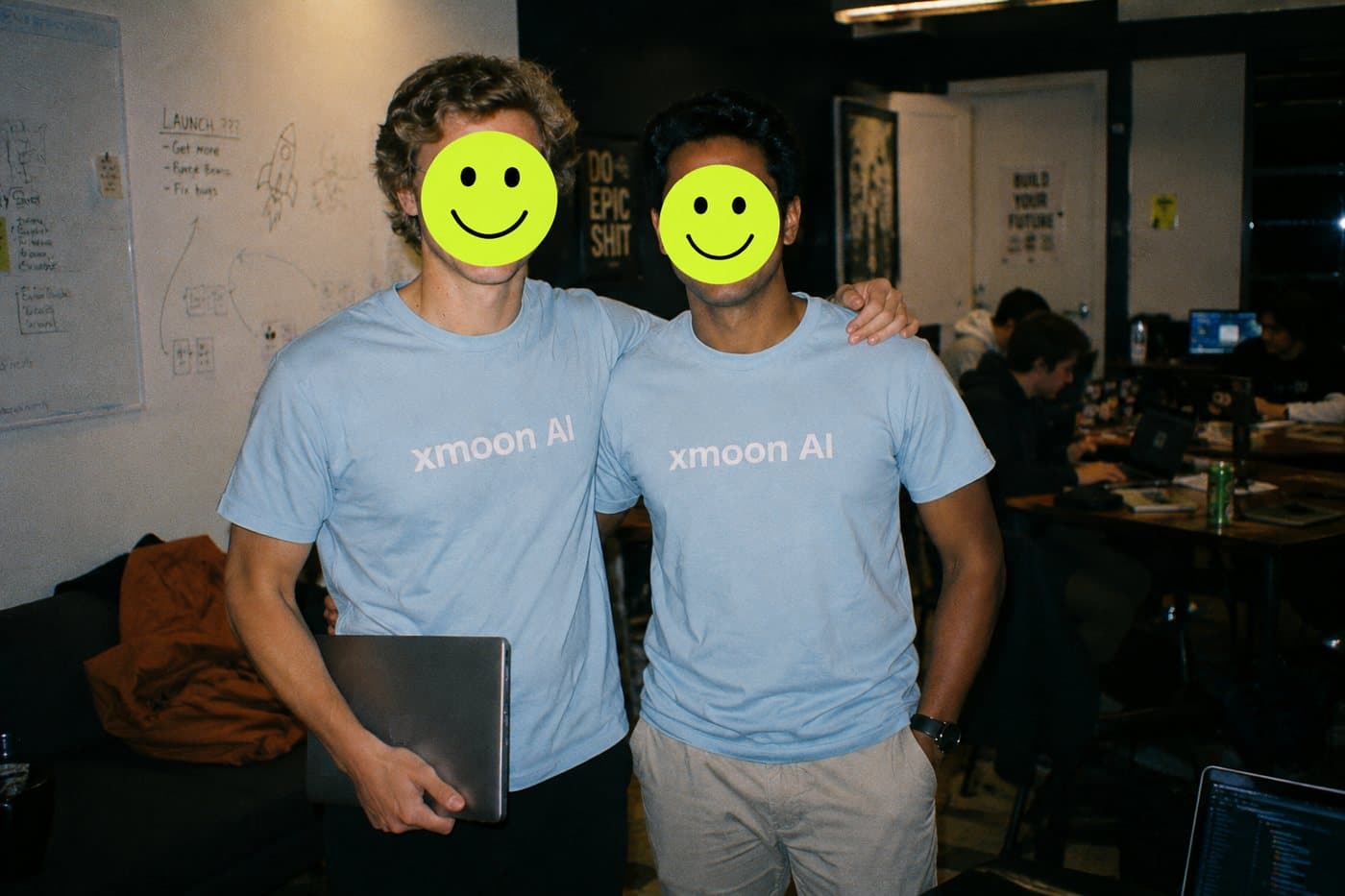Two founders in matching startup t-shirts at a hackathon