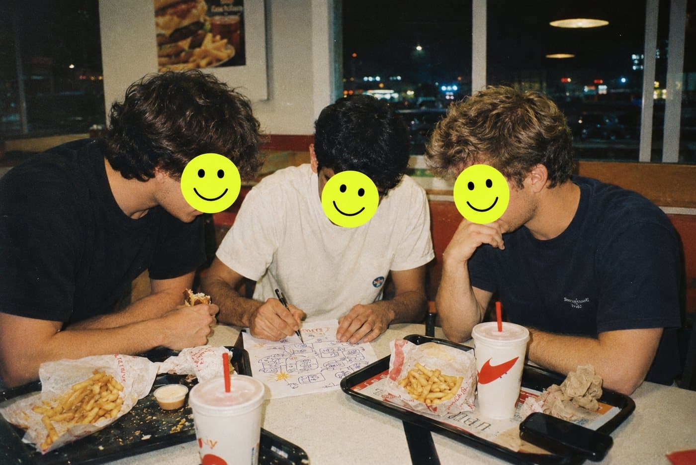 Three founders sketching the product on a napkin over fast food